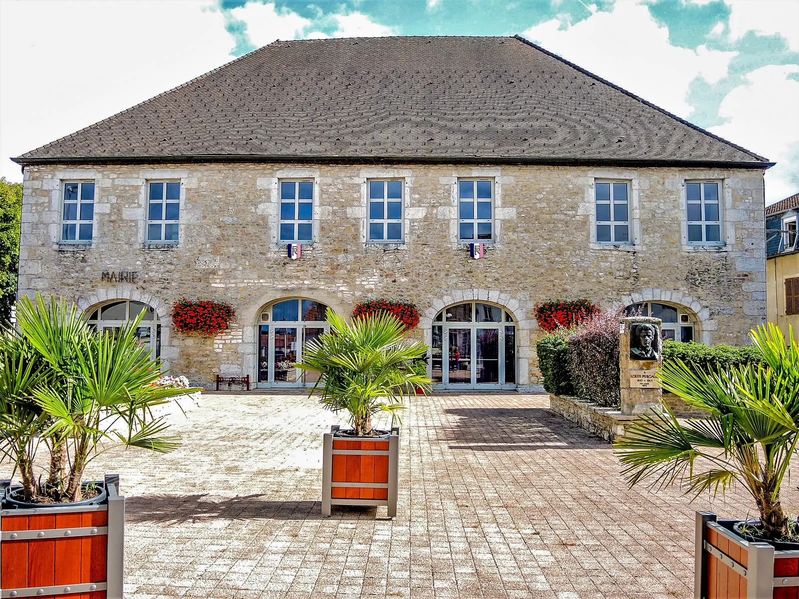 La mairie de Vercel-Villedieu-le-Camp, façade en pierre et arcades sur la place de la Libération